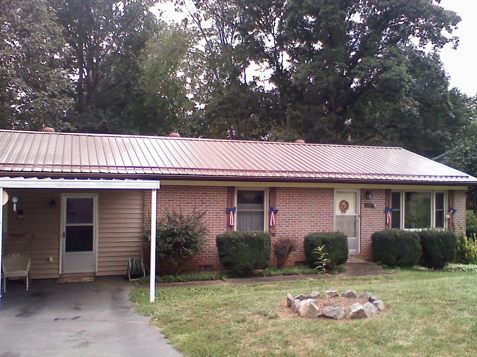 Bronze metal roof and carport on a brick ranch home — Roof Repair work by our crew in Norfolk